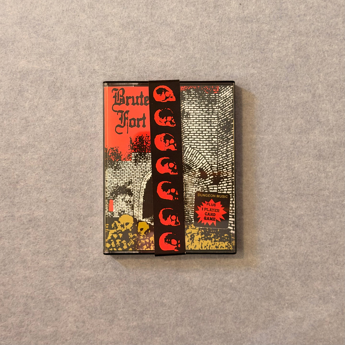 Brute Fort cassette case with red skull band on grey felt