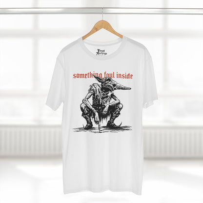 White tee with a black ink crouching goblin under red gothic text reading something foul inside, shown hanging