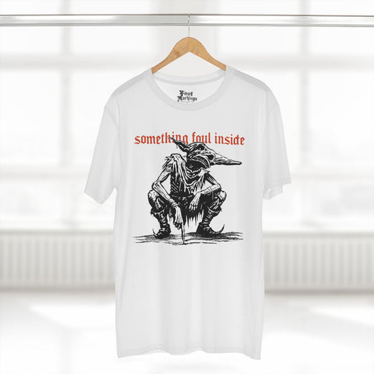 White tee with a black ink crouching goblin under red gothic text reading something foul inside, shown hanging
