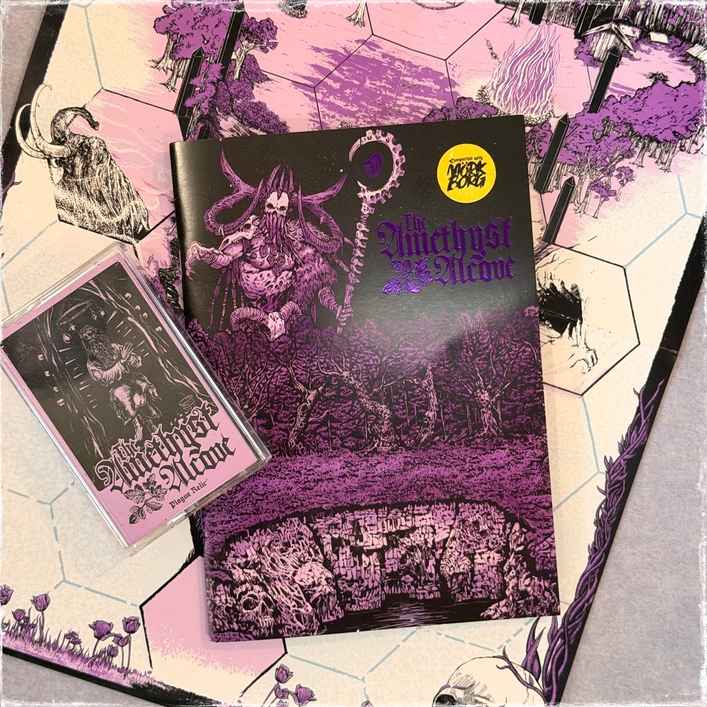 Zine, cassette, and fold-out map laid out together in purple and pink
