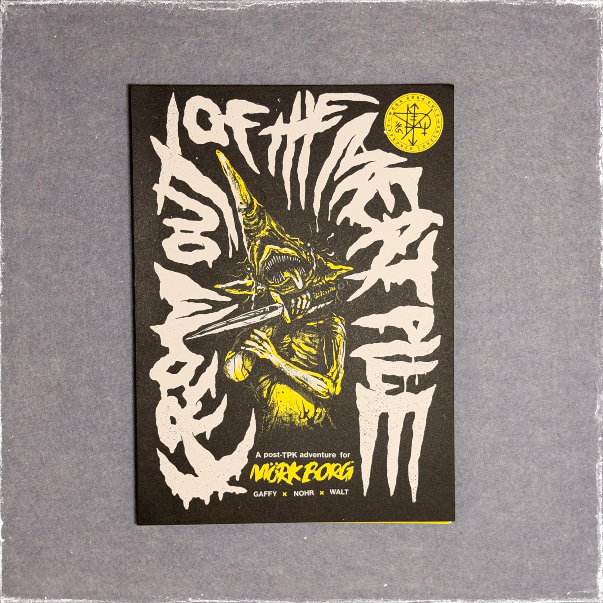 Zine cover in black and yellow, a goblin biting down on a blade