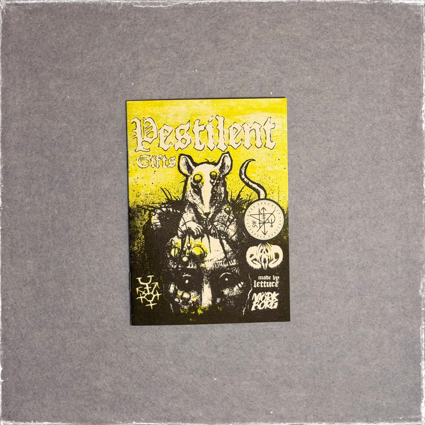 Small zine cover in yellow and black, a rat standing over a pile of skulls