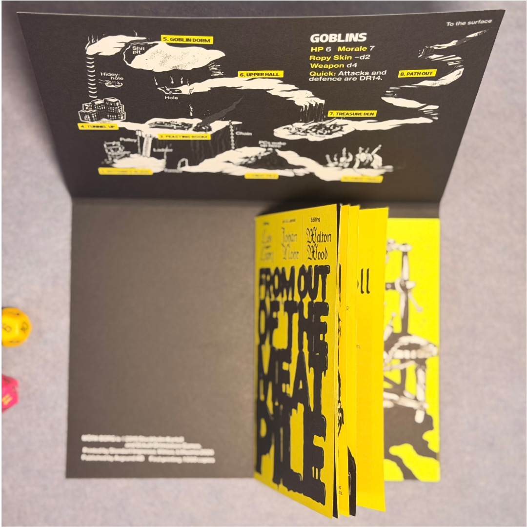 Zine held open beside its fold-out goblin reference page