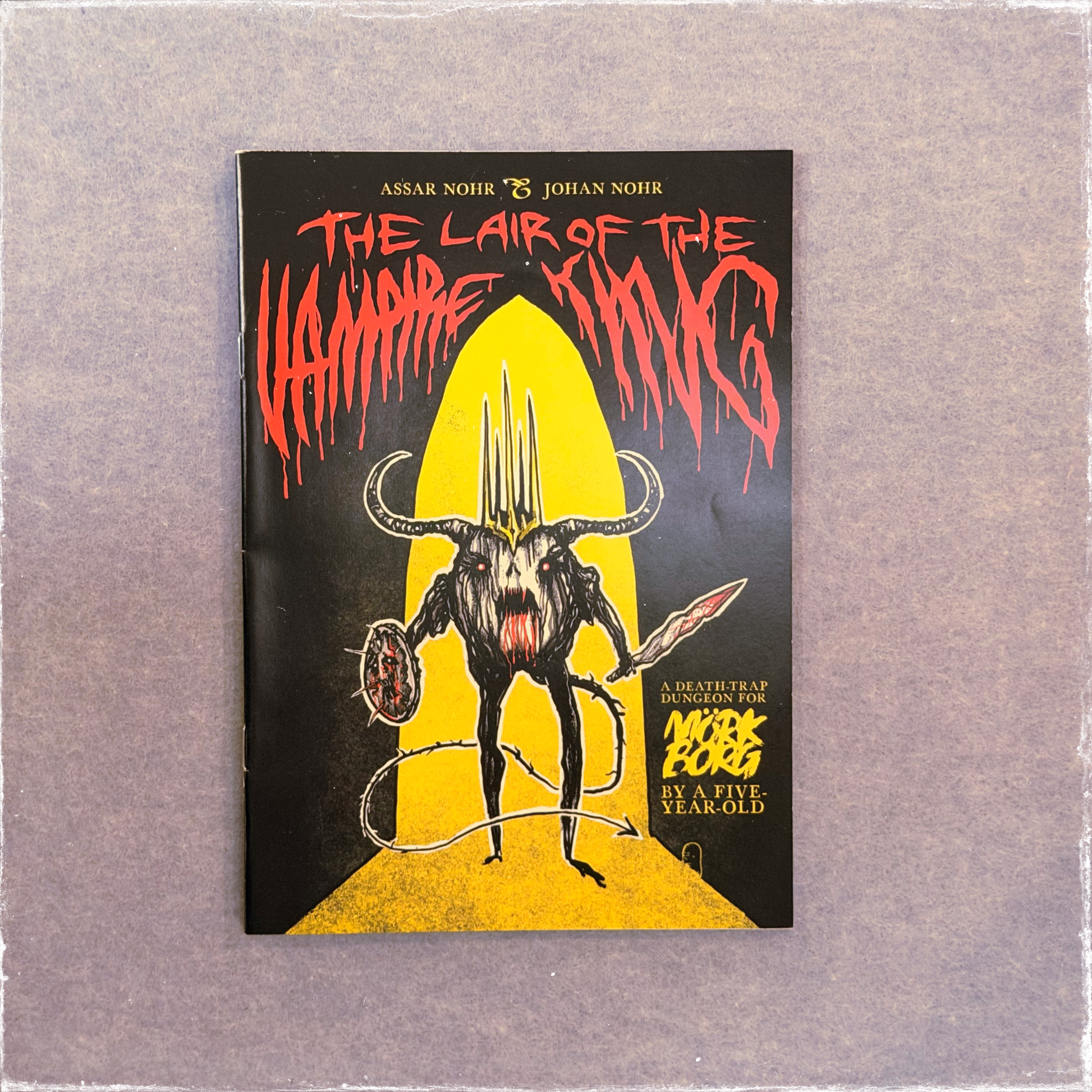 Zine cover in yellow, red, and black, a horned vampire holding a sword in a doorway
